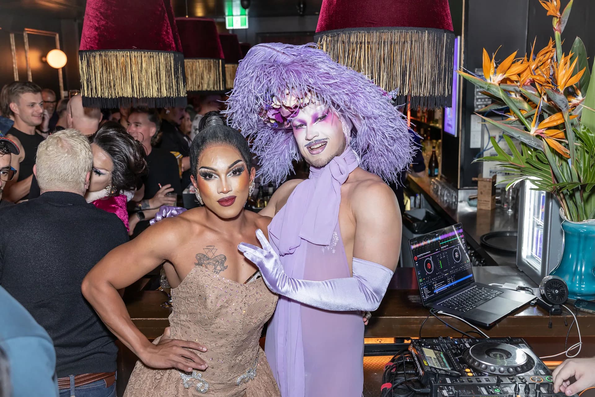 Two drag hosts posing together beside the DJ booth at Stonewall Newtown.